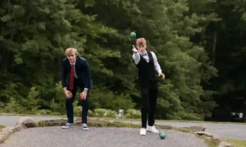 Lawn games like bocce ball and corn hole are available for your wedding guests at cocktail hour at our hillside wedding venue